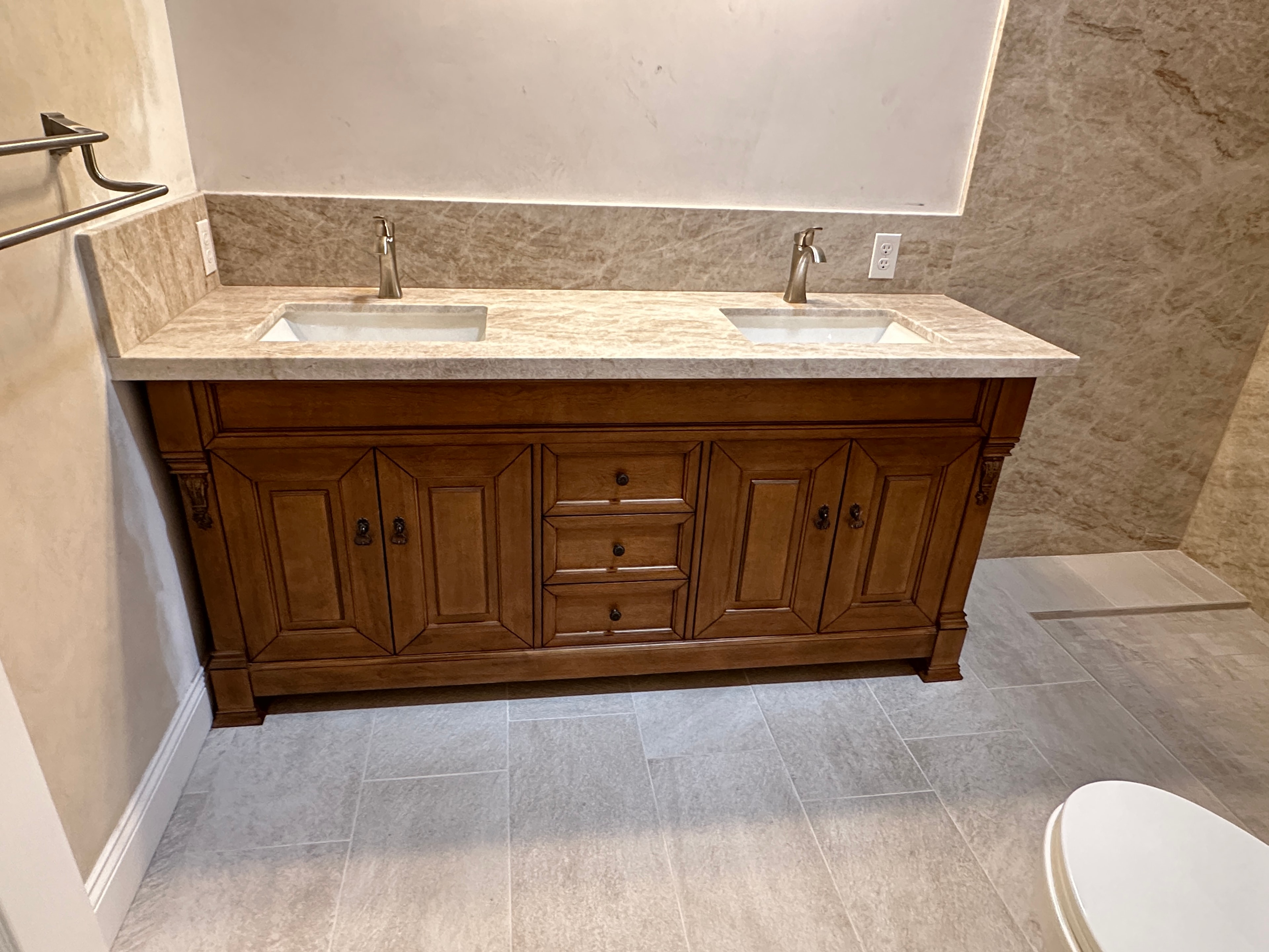 Dual-sink bathroom vanity with marble countertop and wood cabinetry
