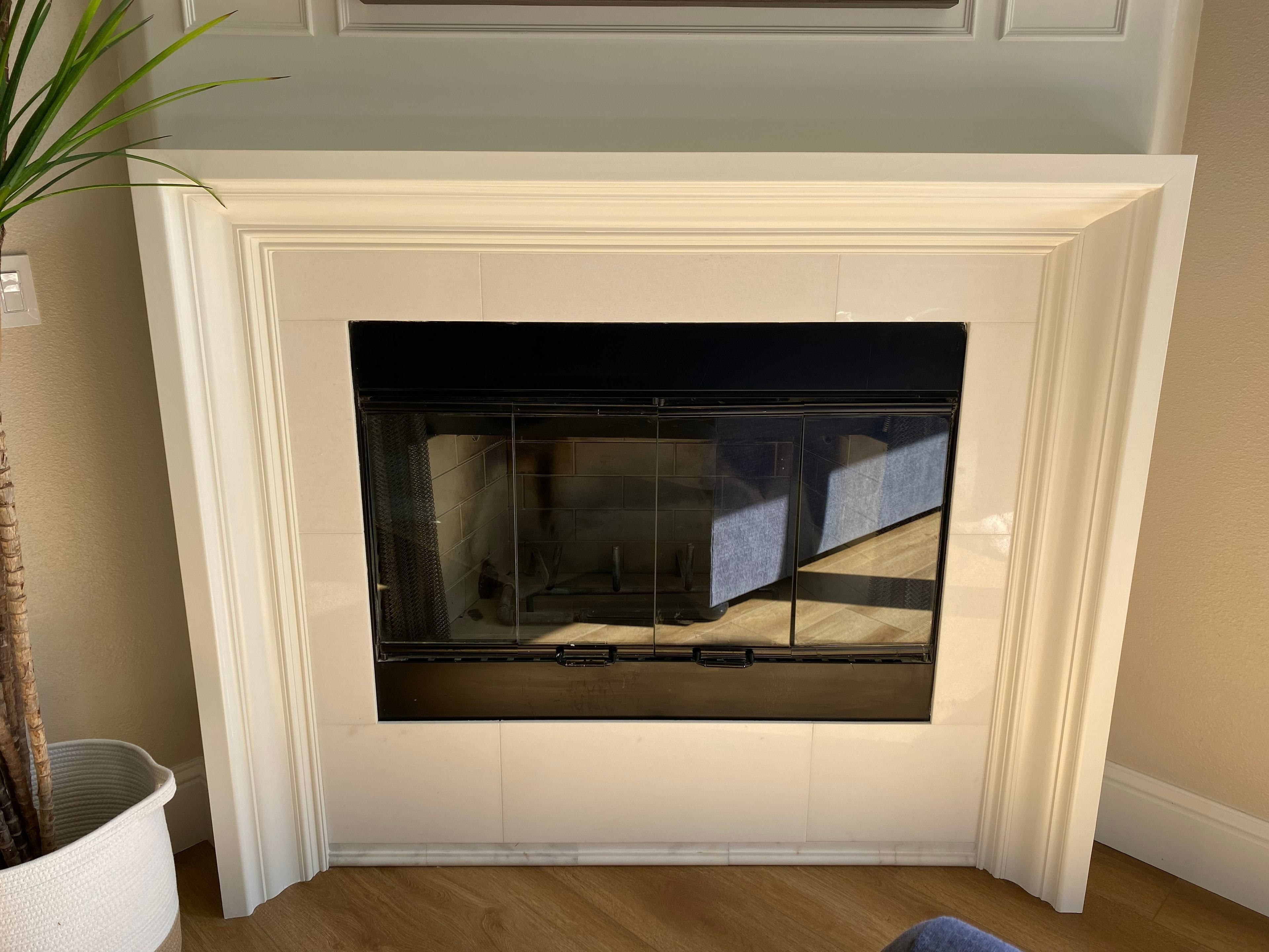 Modern fireplace with glass doors cream surround — HCIC