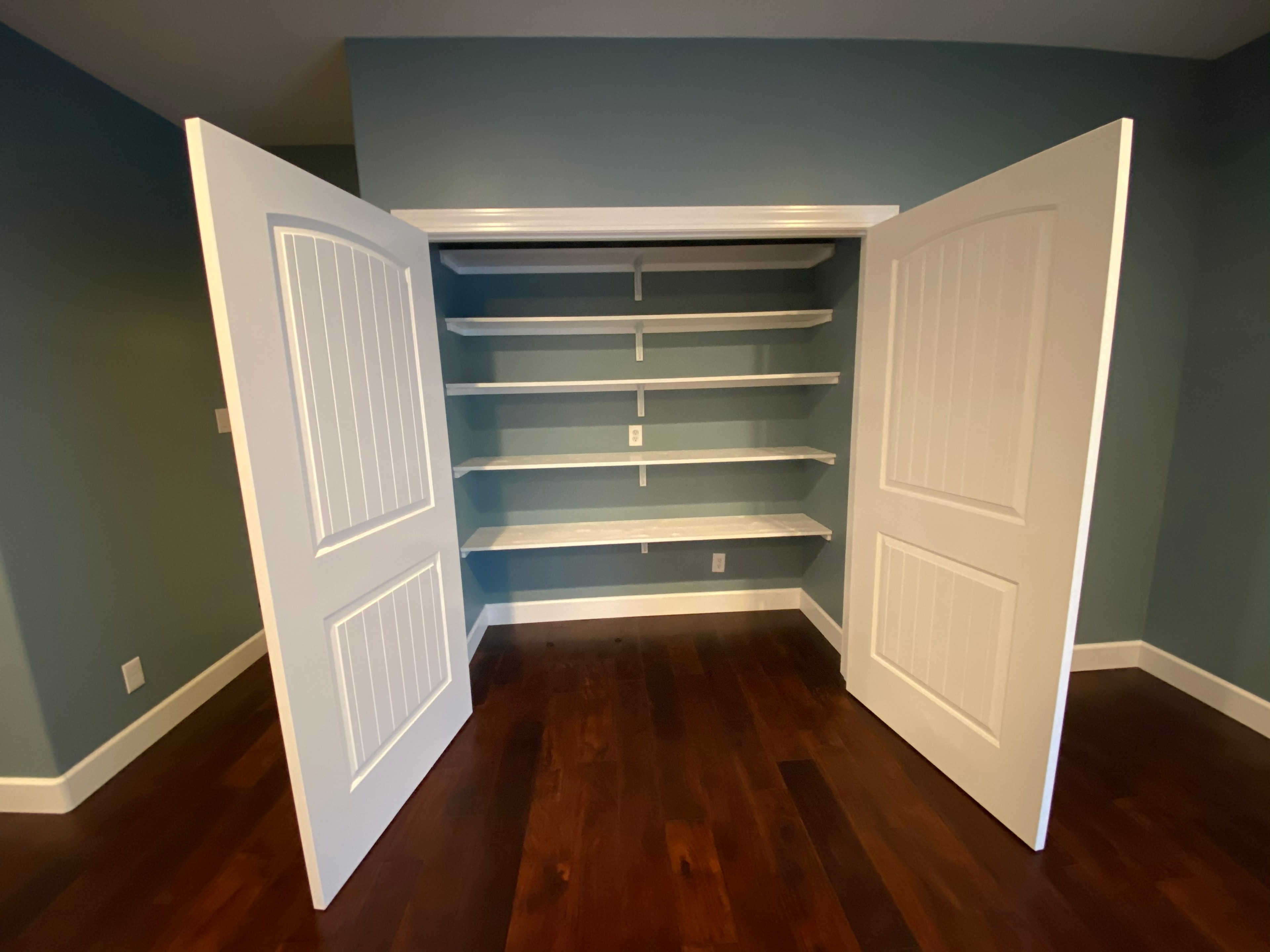 Empty closet with open white doors shelving — HCIC