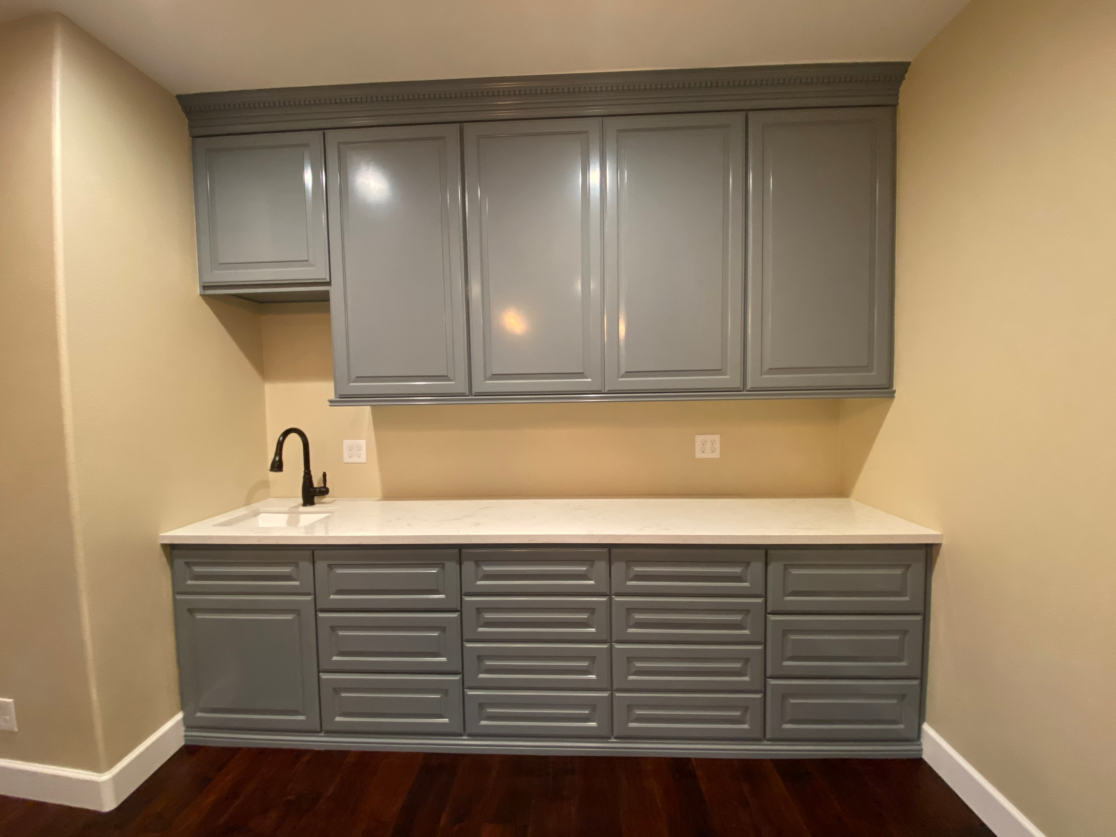 Modern kitchen cabinetry with white countertop — HCIC